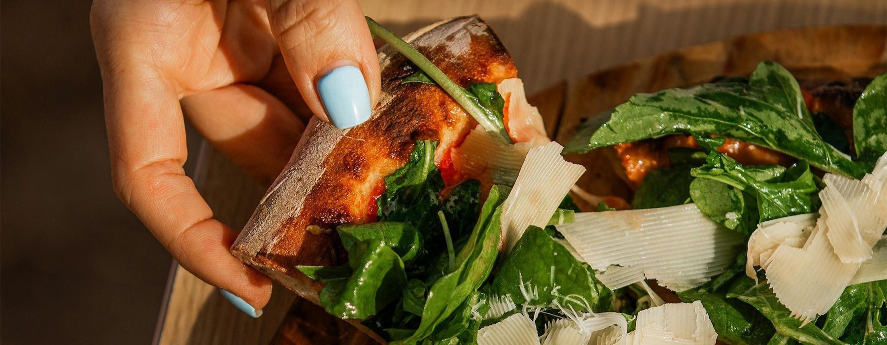 a person holding a slice of pizza