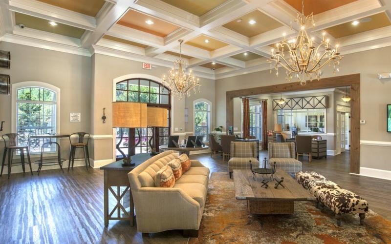 a large living room with a chandelier and a large dining room