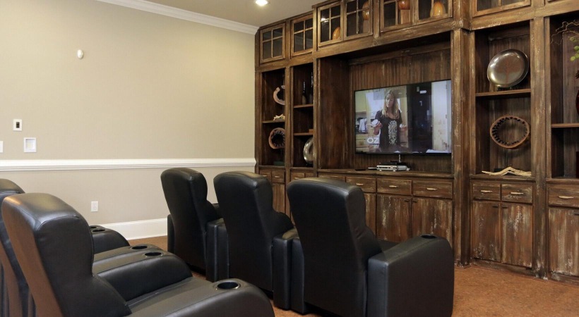a living room with a tv and chairs